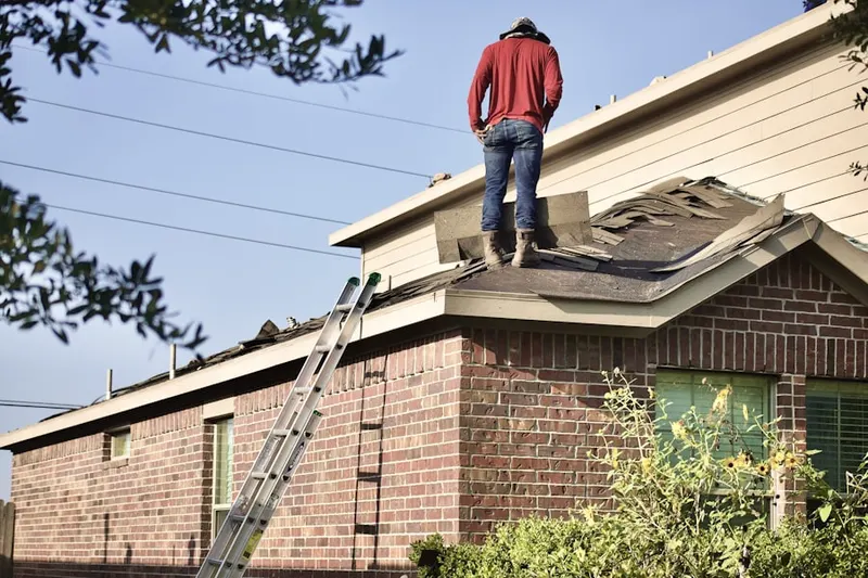 Professional roofer working on a residential roof in Downtown-190th-Riverfront